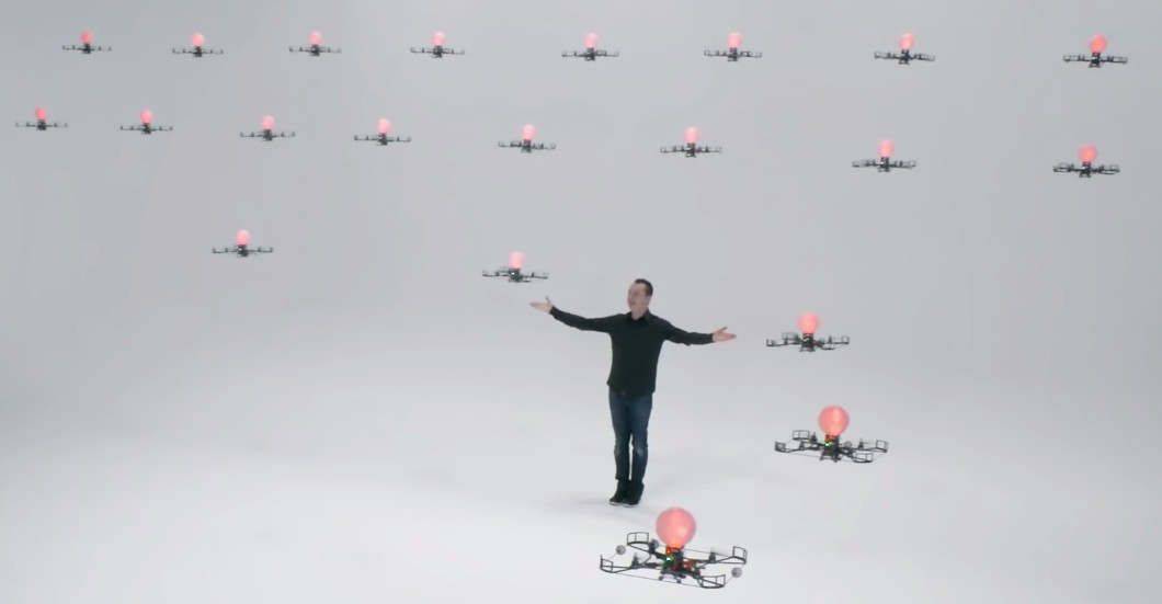 A man standing in front of a group of drones.